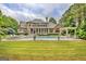 A backyard pool is surrounded by green lawn, landscaping, and an open-air poolside pergola at 310 Westbourne Dr, Tyrone, GA 30290