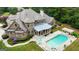 Aerial view of a brick home with a screened porch, pool, spa, pergola and outdoor seating at 310 Westbourne Dr, Tyrone, GA 30290