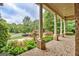 Covered front porch with brick flooring, decorative columns, and a view of the landscaped front yard at 310 Westbourne Dr, Tyrone, GA 30290