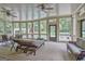 Cozy screened porch with ceiling fans, lounge chairs, and dining table overlooking the pool and lush backyard at 310 Westbourne Dr, Tyrone, GA 30290