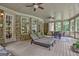 Enclosed back porch featuring wicker furniture, a dining table, and a view of the landscaped backyard at 310 Westbourne Dr, Tyrone, GA 30290
