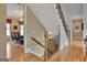A staircase with decorative metal railings, hardwood floors, and views into the dining room at 310 Westbourne Dr, Tyrone, GA 30290