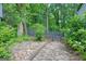 Charming backyard with stone patio, lush landscaping, and a classic wood fence at 7025 Stone Wood Nw Dr, Kennesaw, GA 30152