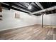 An open unfinished basement with exposed ceiling, wooden shelves, and vinyl flooring at 7025 Stone Wood Nw Dr, Kennesaw, GA 30152