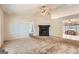 A carpeted living room with a fireplace, a ceiling fan, and a view leading into a dining area at 113 Hitchcock Dr, Villa Rica, GA 30180