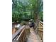 Multi-level deck in a wooded backyard with outdoor seating at 974 Bloomfield Dr, Lawrenceville, GA 30044