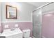 Bathroom featuring pink tiling, vanity, toilet, and shower with glass doors at 1189 E Fayetteville Rd, Riverdale, GA 30296