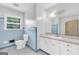 Bathroom with blue tile accents, a vanity with ample storage, and a mirror that reflects natural light from the window at 1189 E Fayetteville Rd, Riverdale, GA 30296