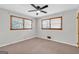 Bedroom with neutral carpet, two windows, and a ceiling fan for comfort at 1189 E Fayetteville Rd, Riverdale, GA 30296