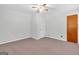 Bedroom has neutral carpet, a door leading out, and a ceiling fan at 1189 E Fayetteville Rd, Riverdale, GA 30296