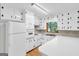 Efficient kitchen featuring white cabinetry, a range, ample counter space, and a window for natural light during meal prep at 1189 E Fayetteville Rd, Riverdale, GA 30296