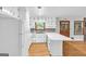 Kitchen featuring white cabinets and an island, complemented by hardwood floors and lots of natural light from the window at 1189 E Fayetteville Rd, Riverdale, GA 30296
