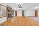 Bright, open living room showcasing hardwood floors, a ceiling fan, and a stone fireplace, perfect for entertaining at 1189 E Fayetteville Rd, Riverdale, GA 30296