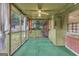 View of enclosed porch with green carpet and ceiling fan at 1189 E Fayetteville Rd, Riverdale, GA 30296