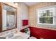 Bathroom featuring red and patterned wallpaper, a vanity with sink, and a window view at 3359 Villa Ln, Douglasville, GA 30135