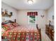 Bedroom featuring a bed with colorful quilt, wooden dresser, and window with valance at 3359 Villa Ln, Douglasville, GA 30135