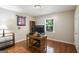 Bedroom with a wood desk, wood floors, a window with blinds, and a neutral wall color at 3359 Villa Ln, Douglasville, GA 30135