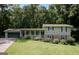 Charming two-story home with a well-maintained lawn and beautiful landscaping, including mature trees at 3359 Villa Ln, Douglasville, GA 30135