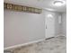 Finished basement room with tile floors, white door and trim, and decorative wallpaper border at 3359 Villa Ln, Douglasville, GA 30135