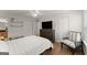 Spacious main bedroom with hardwood floors, ceiling fan, and a large flat screen television at 603 Brighton Pt, Atlanta, GA 30328