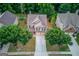 An aerial view of the two-story home with green lawn and some surrounding trees at 2030 Beyers Landing Dr, Buford, GA 30519