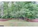 A well-maintained backyard features a lush lawn and a wood privacy fence, surrounded by mature trees at 2030 Beyers Landing Dr, Buford, GA 30519