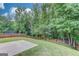 Expansive backyard with a concrete patio, and a wood privacy fence, bordered by mature trees, offering ample space at 2030 Beyers Landing Dr, Buford, GA 30519