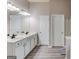 Bathroom featuring double sink vanity with white cabinets, dark fixtures and plank flooring at 2030 Beyers Landing Dr, Buford, GA 30519
