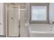 Bright bathroom with glass-door shower and separate tub, offering relaxation and convenience at 2030 Beyers Landing Dr, Buford, GA 30519
