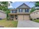 Charming two-story home features a two-car garage, and a well-manicured lawn at 2030 Beyers Landing Dr, Buford, GA 30519