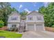 Inviting two-story home featuring a two-car garage and a well-maintained front yard with vibrant flowers at 3781 Deercreek Dr, Powder Springs, GA 30127