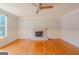 Light-filled living room showcasing a fireplace, hardwood floors, neutral paint, and ceiling fan at 3781 Deercreek Dr, Powder Springs, GA 30127
