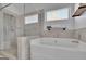 Bright bathroom with soaking tub, walk-in shower, and tiled walls at 4520 Odum Lake Trl, Cumming, GA 30040