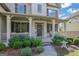 Charming front porch featuring classic columns, brick steps, decorative shrubbery, and inviting wreath at 4520 Odum Lake Trl, Cumming, GA 30040