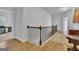 Hallway with hardwood floors, decorative rug and staircase with iron spindles at 4520 Odum Lake Trl, Cumming, GA 30040