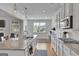 Bright kitchen featuring granite countertops, stainless steel appliances, white cabinets, and hardwood floors at 4520 Odum Lake Trl, Cumming, GA 30040