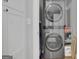 Convenient laundry area with stacked washer and dryer unit, next to storage and cleaning supplies at 4520 Odum Lake Trl, Cumming, GA 30040