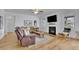 Cozy living room featuring hardwood floors, fireplace, tv, comfortable seating and ample natural light at 4520 Odum Lake Trl, Cumming, GA 30040