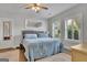 Serene bedroom with hardwood floors, light blue bedding, and bright natural light from two windows at 4520 Odum Lake Trl, Cumming, GA 30040