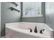 Soaking tub in bathroom features stylish fixtures and window at 142 Holly Mill Village Dr, Canton, GA 30114