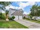 Well-manicured front lawn and two car garage add to the curb appeal of this lovely two-story house at 142 Holly Mill Village Dr, Canton, GA 30114