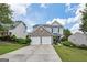 Charming two-story home with a two-car garage, stone accents, manicured lawn and inviting curb appeal at 142 Holly Mill Village Dr, Canton, GA 30114