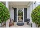 Inviting covered porch features a decorative trimmed door, small bench, and potted plants, welcoming guests at 142 Holly Mill Village Dr, Canton, GA 30114
