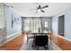 Bright dining room featuring a large table with stylish chairs, wood floors, and natural light from multiple windows at 1694 Pheasant Dr, Atlanta, GA 30238