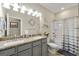 Well-lit bathroom featuring double vanity with granite counters and shower-tub combo at 3735 Westhaven Dr, Cumming, GA 30040