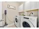 Clean laundry room featuring modern washer and dryer, plus upper cabinets for supplies, making chores a breeze at 3735 Westhaven Dr, Cumming, GA 30040