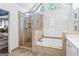 Light-filled primary bathroom with a jacuzzi tub, seamless shower, and custom shuttered window at 4729 Woodland Brook Se Ct, Atlanta, GA 30339