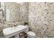 Powder room with floral wallpaper, pedestal sink, and neutral color scheme at 4729 Woodland Brook Se Ct, Atlanta, GA 30339