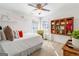 This bright bedroom includes custom shelving, artwork, and a ceiling fan at 4729 Woodland Brook Se Ct, Atlanta, GA 30339