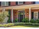 Inviting front entryway with black door, sidelights, brick facade, manicured landscaping and address number at 4729 Woodland Brook Se Ct, Atlanta, GA 30339